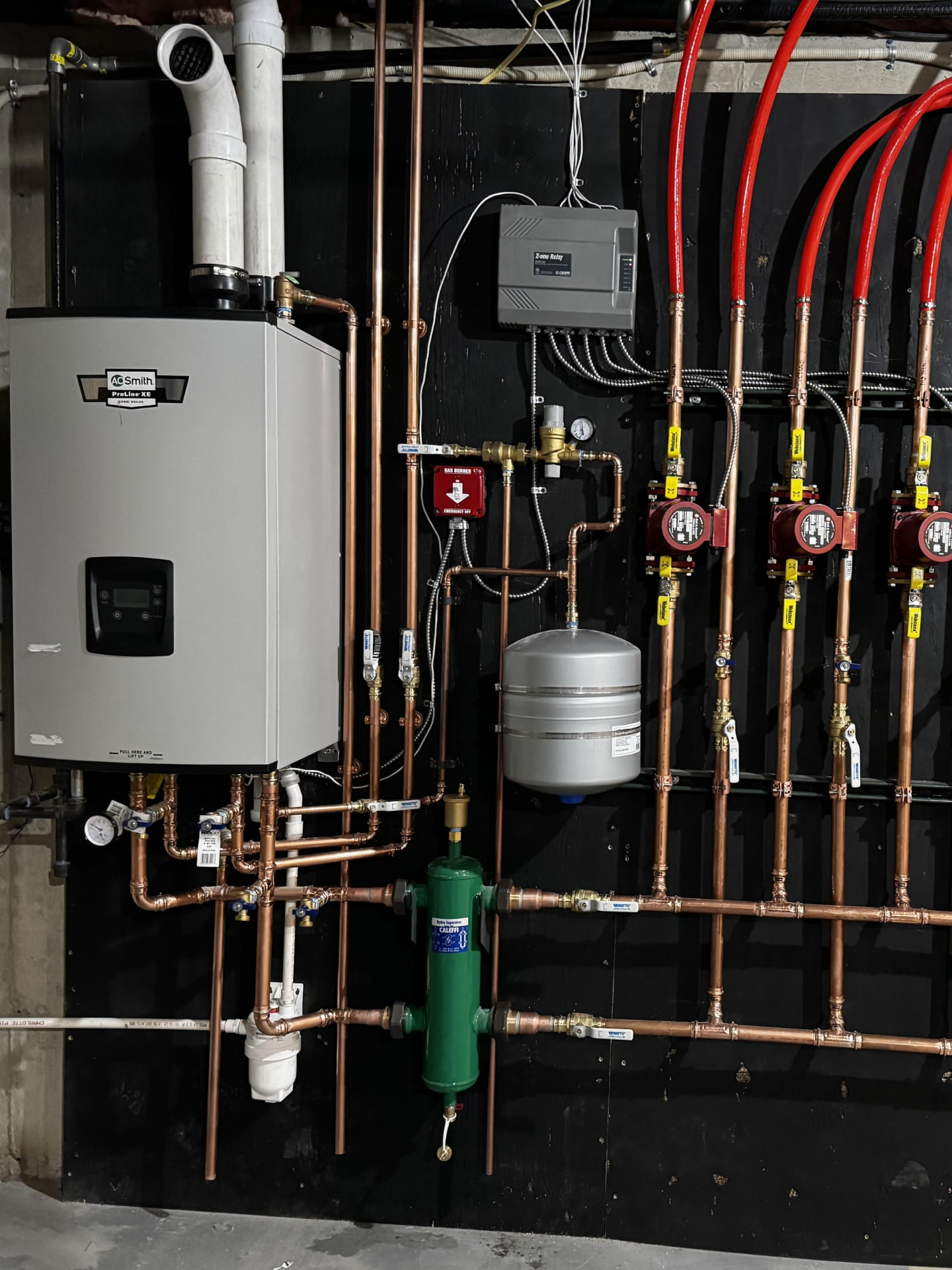 High efficiency boiler with a copper zone manifold and circulators installed in a Totowa basement
